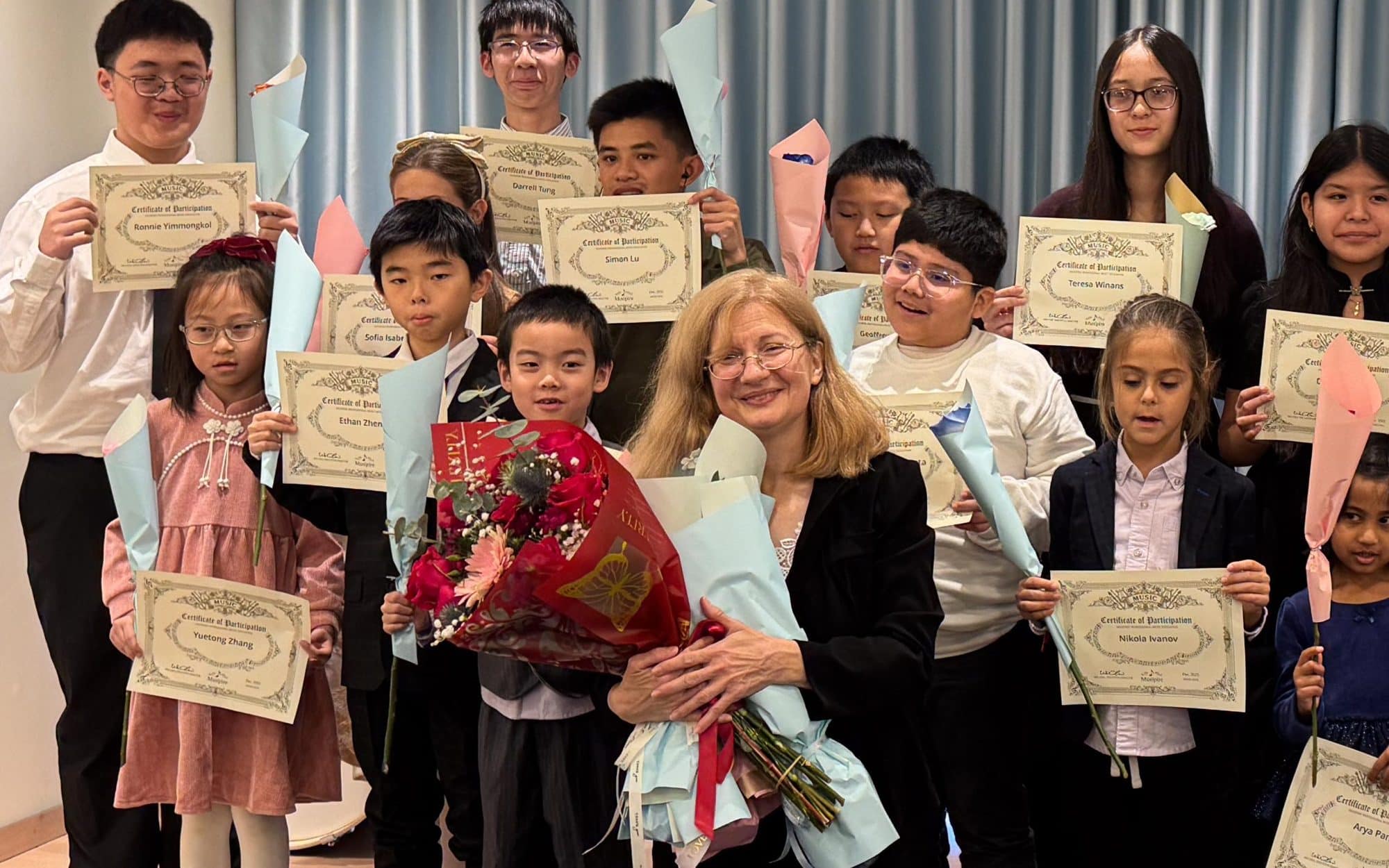 A Musipire teacher celebrating with her students and their Certificates of Participation after a concert